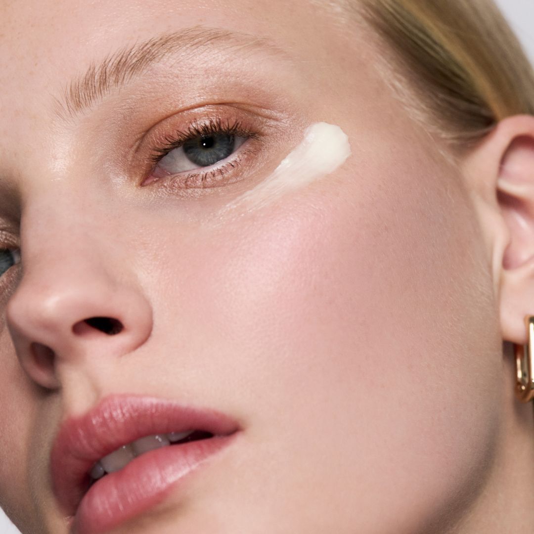 Applicazione di un velo di crema sugli zigomi di una donna.