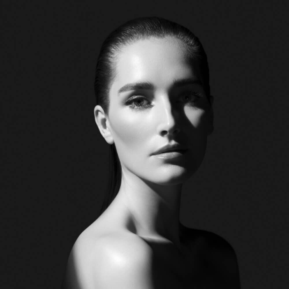  Ritratto in bianco e nero di una donna con illuminazione drammatica.