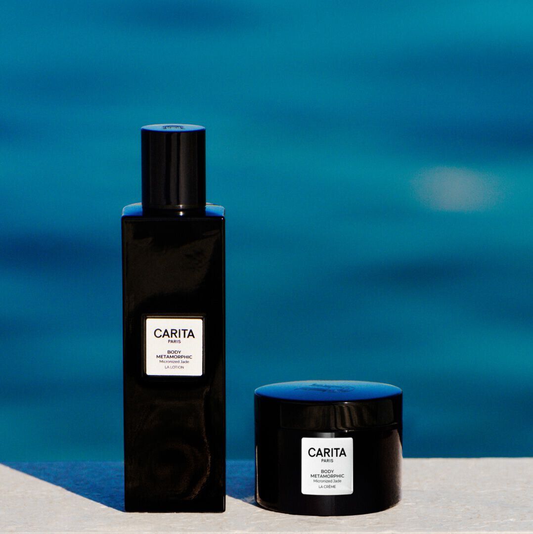Flacone e vasetto neri della linea Body Metamorphic di Carita su sfondo nero.