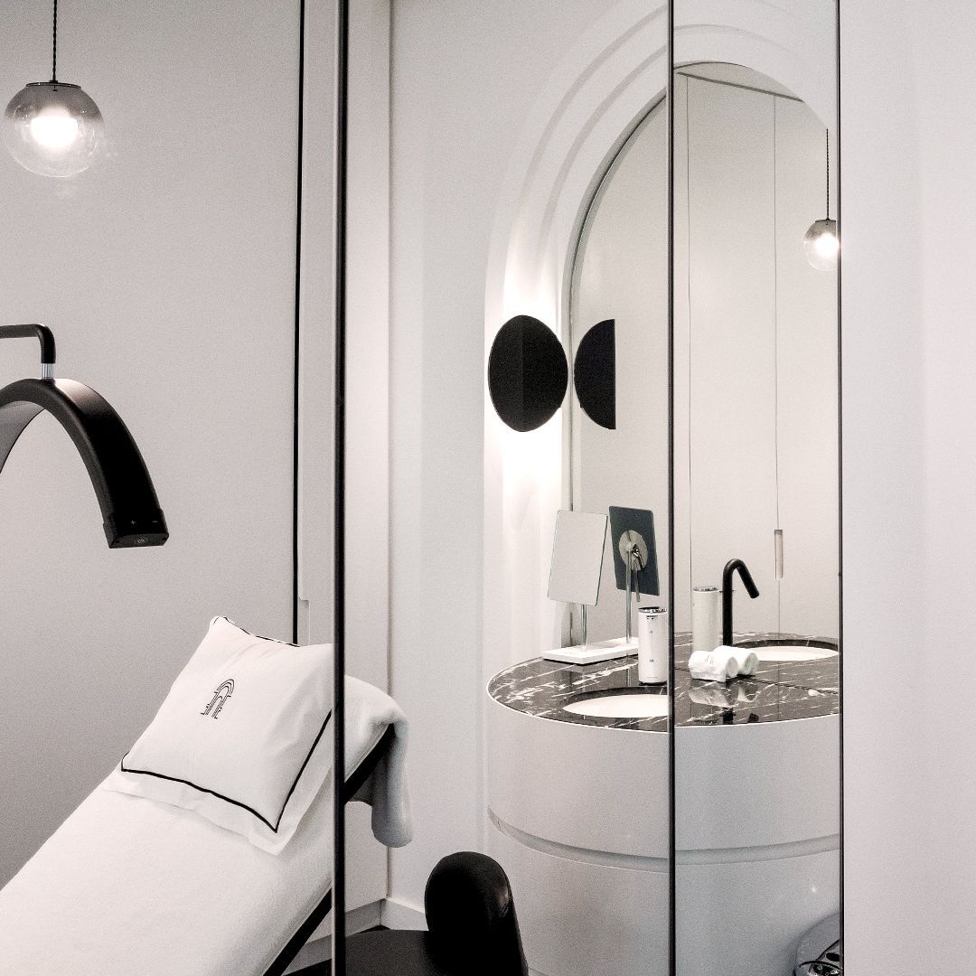 Studio ciglia/sopracciglia moderno ed elegante con poltrona, specchi e lavabo in marmo. Lo spazio e luminoso e dal design pulito.