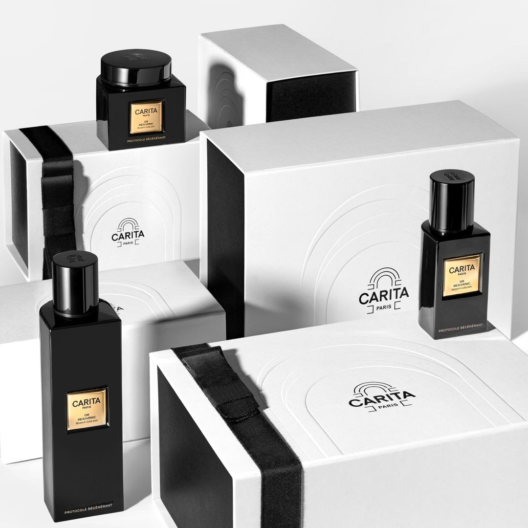 Immagine di diverse bottiglie di profumo nere disposte su scatole bianche con dettagli eleganti.