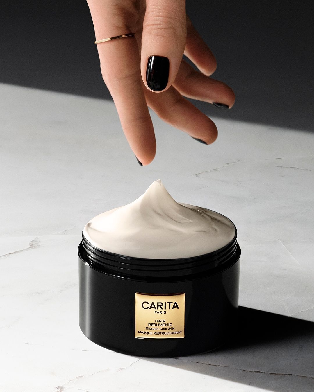 Mano che preleva la crema dal barattolo della maschera Hair Rejuvenic.