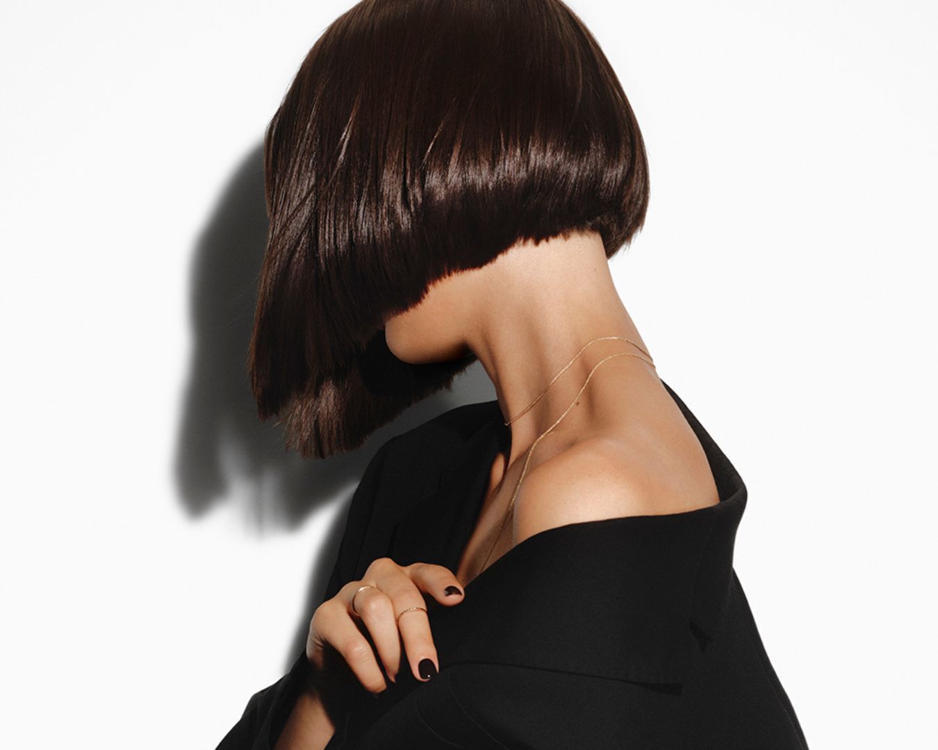 Donna bruna con capelli castani tagliati a caschetto corto e lisci.