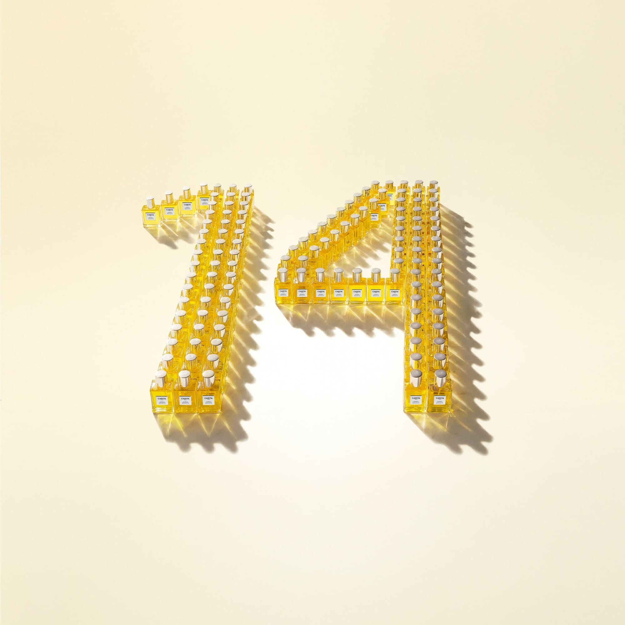 Installazione artistica dei flaconi Carita che formano il numero 14. Una messa in scena grafica e lussuosa che celebra l icona della Maison in un bagliore di oro e luce.