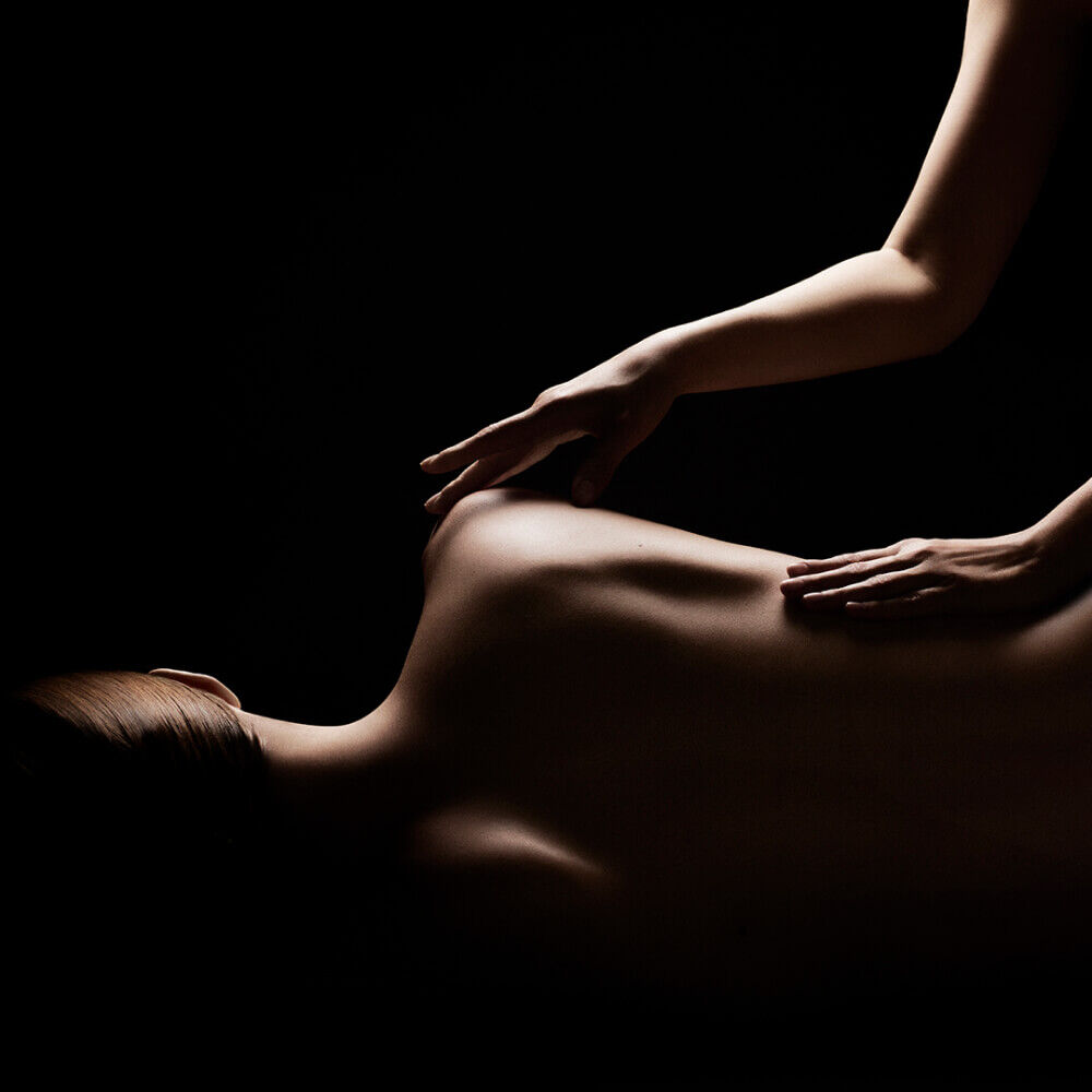 Ombre drammatiche e contrastate su un massaggio manuale schiena.