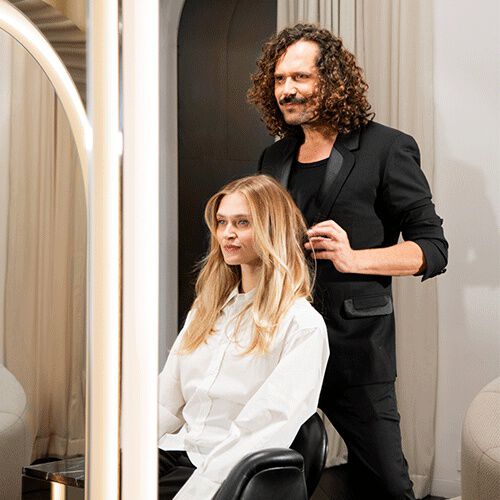 Una donna con una camicia bianca si trova comodamente seduta su un divano.